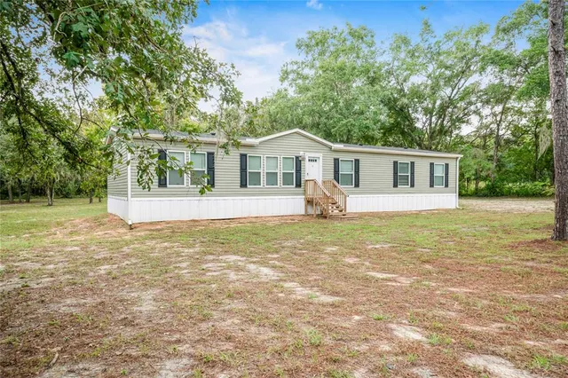 a view of a house with a backyard and a tree