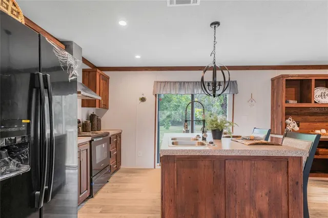 a kitchen with stainless steel appliances a sink cabinets and a wooden floor