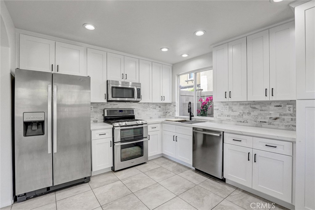 12 Poppyfield Lane Rancho Santa Margarita, CA 92688 - Photo 4 of 35 a kitchen with white cabinets stainless steel appliances and a window