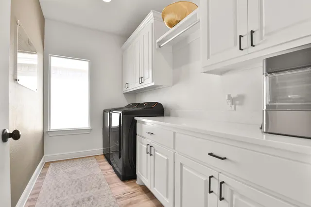 a kitchen with white cabinets and refrigerator