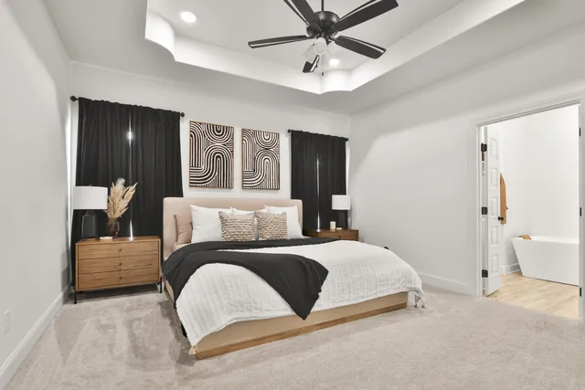 a bedroom with a large bed and chandelier fan
