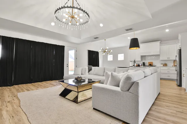a living room with furniture and a chandelier
