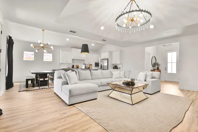 a living room with furniture and a chandelier
