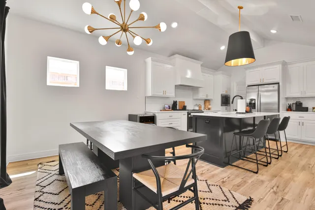 a kitchen with a dining table cabinets and stainless steel appliances