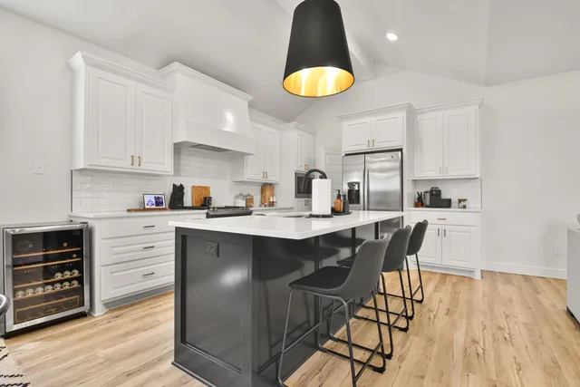 a kitchen with a table chairs a sink dishwasher stove and cabinets with wooden floor