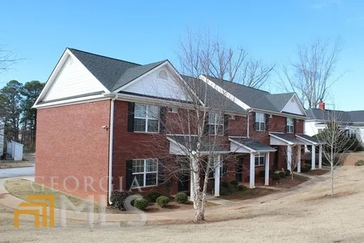 a view of a big house with wooden fence