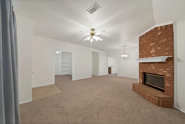 an empty room with fireplace and fan