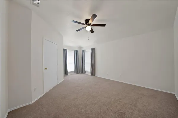 a view of a livingroom with a ceiling fan & window
