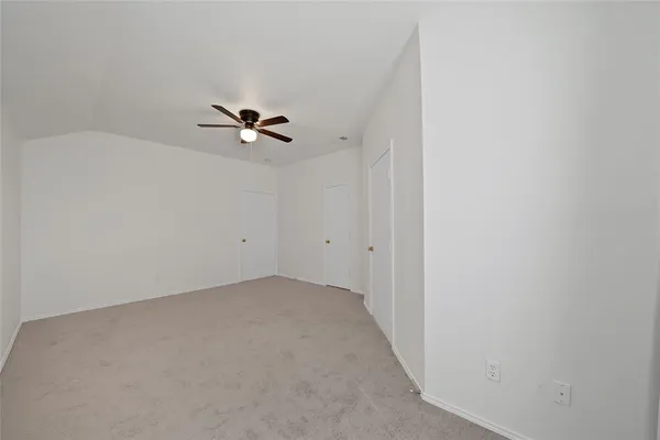 an empty room with a ceiling fan and a window