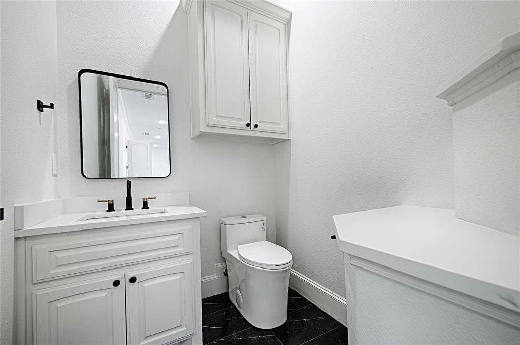 6301 Churchill Way Dallas, TX 75230 - Photo 29 of 40 Bathroom with baseboards, vanity, and toilet