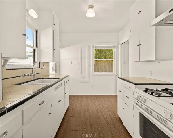 a kitchen with granite countertop white cabinets and white appliances