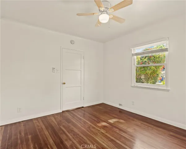 an empty room with a window and ceiling fan