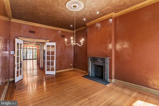 a view of an empty room with wooden floor and windows
