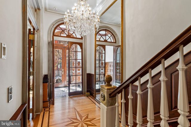 a view of a hallway with wooden floor and a chandelier