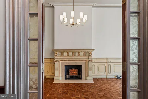 a view of a hallway with wooden floor and chandelier
