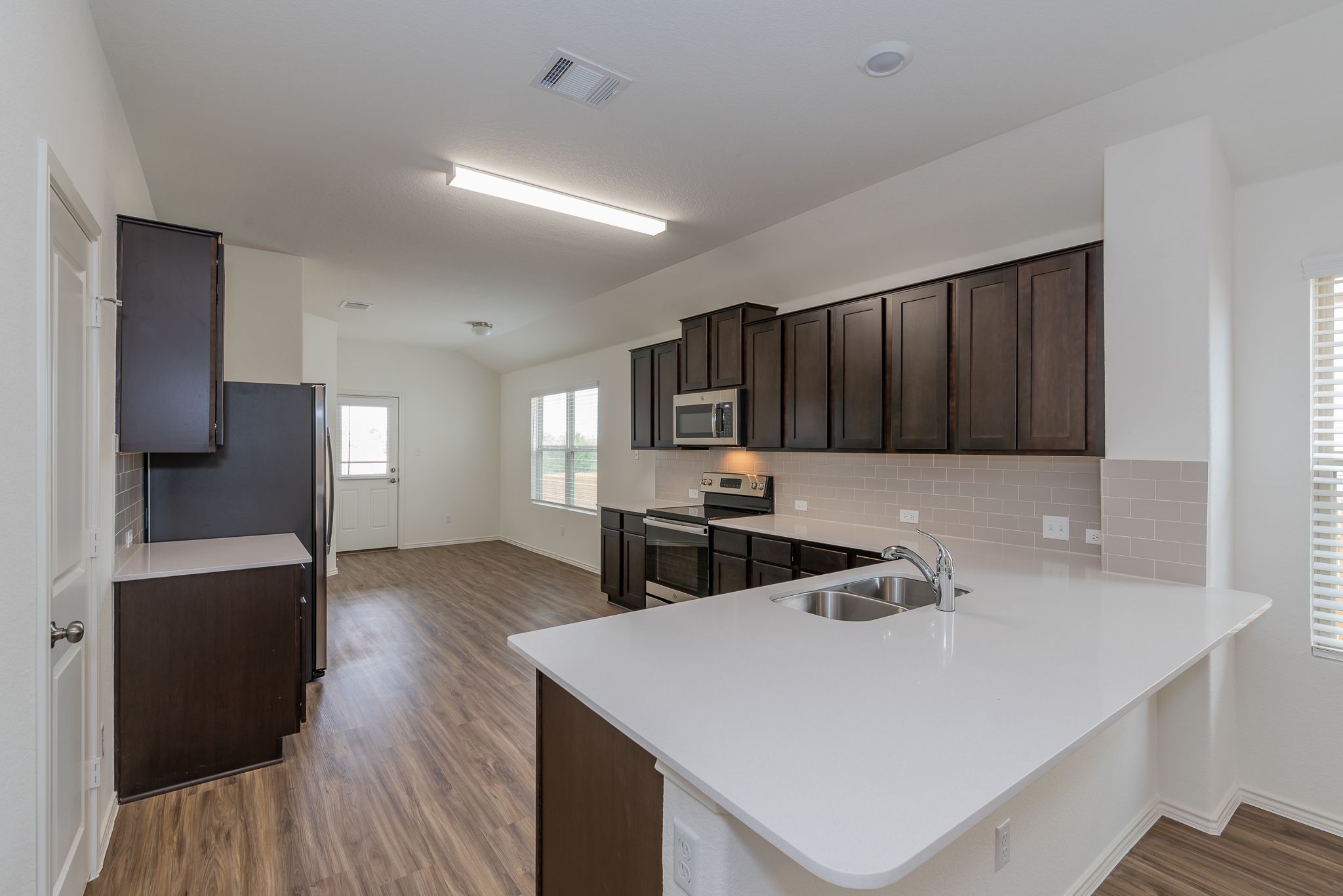 509 Greatest Gift Way Jarrell, TX 76537 - Photo 7 of 28 a kitchen with sink cabinets and wooden floor