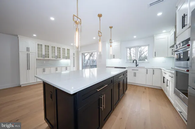 a kitchen with a sink a counter top space stainless steel appliances and cabinets