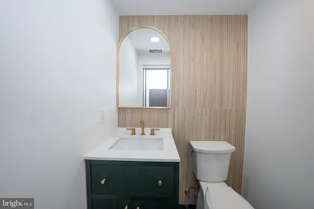 a bathroom with a toilet sink and mirror