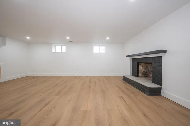 an empty room with wooden floor and fireplace