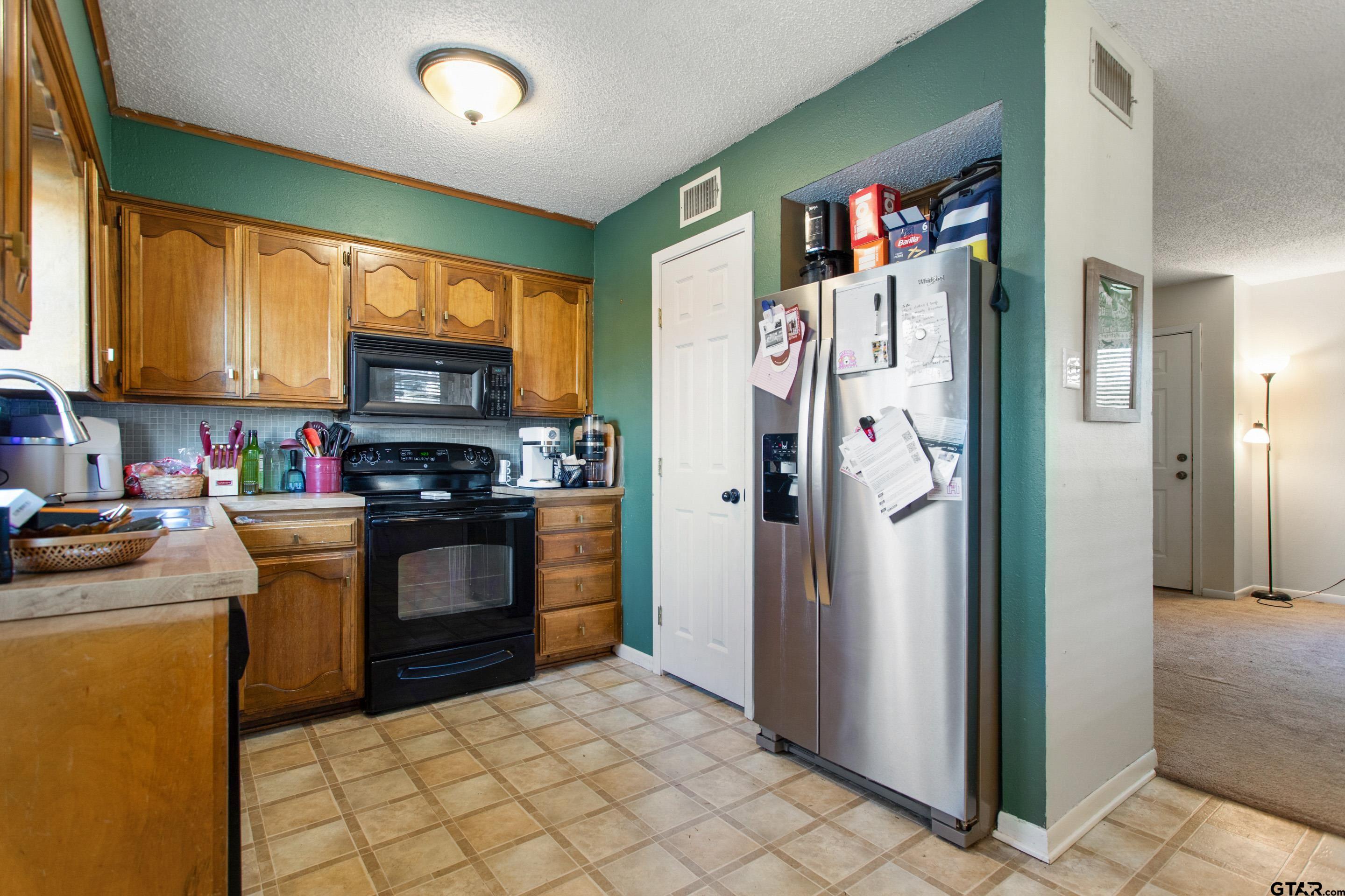 a kitchen with stainless steel appliances granite countertop a refrigerator and a stove