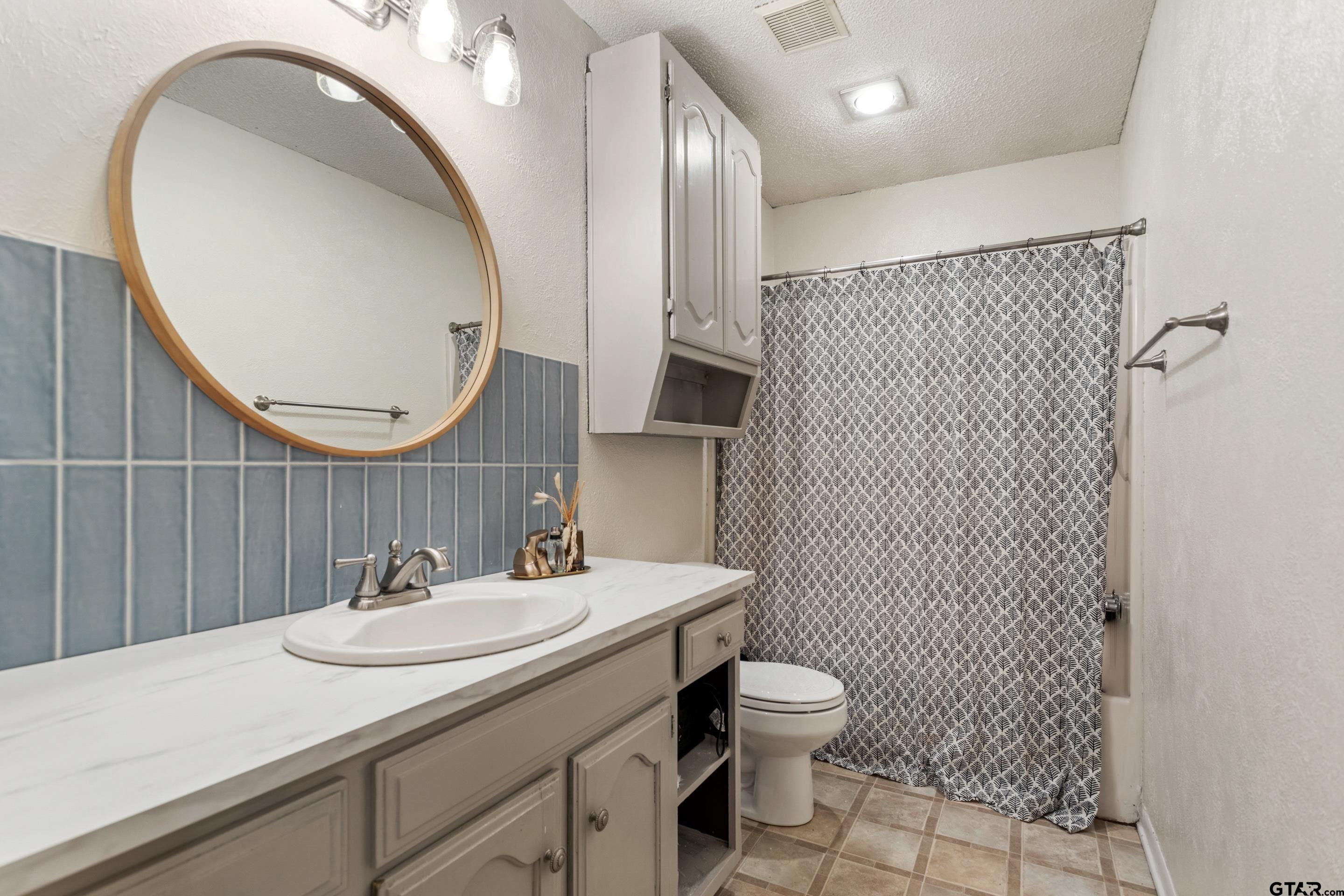 1106 Brad Circle Lindale, TX 75771 - Photo 25 of 27 a bathroom with a sink a toilet and mirror