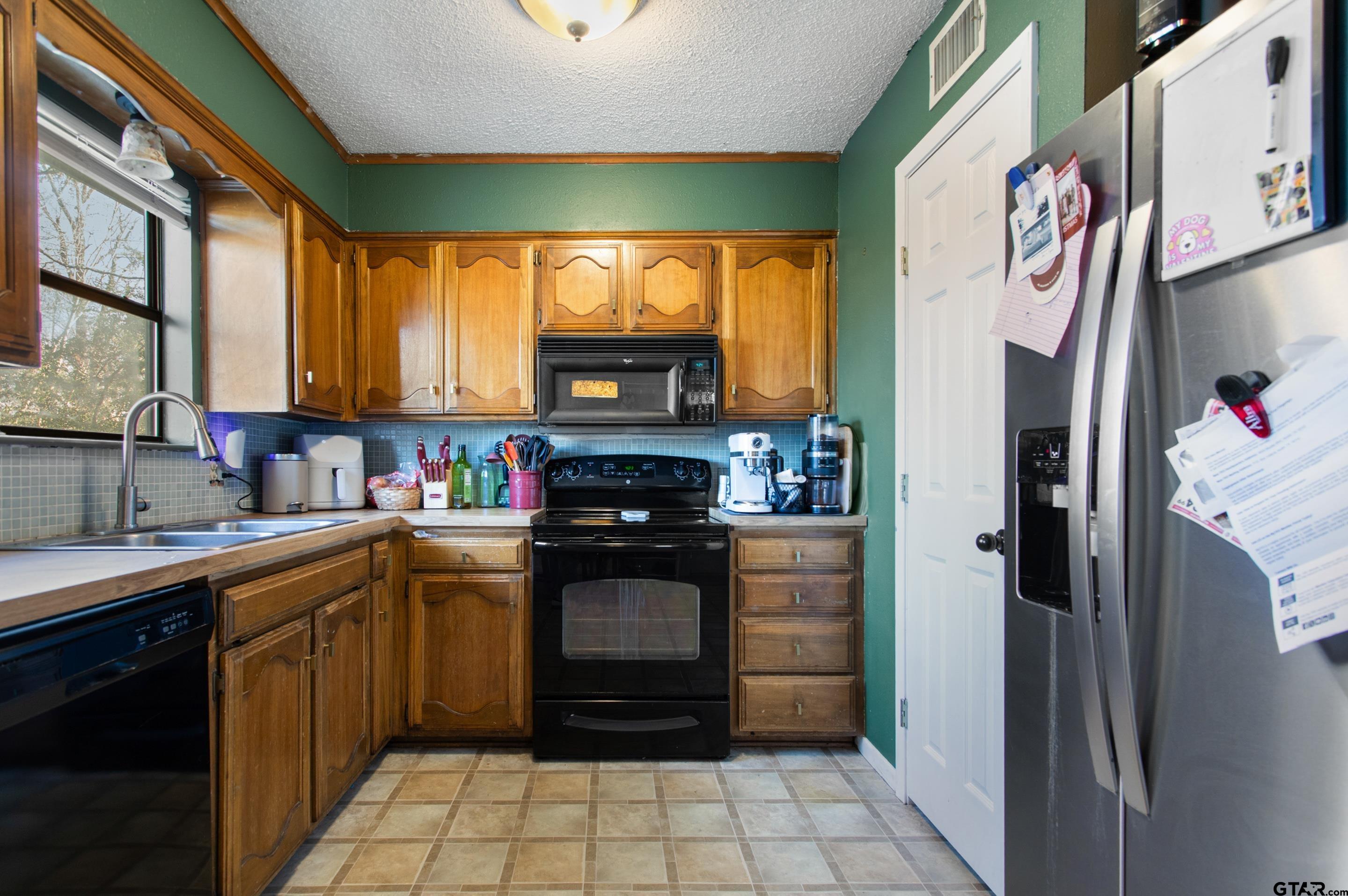 1106 Brad Circle Lindale, TX 75771 - Photo 7 of 27 a kitchen with stainless steel appliances granite countertop a refrigerator and a sink