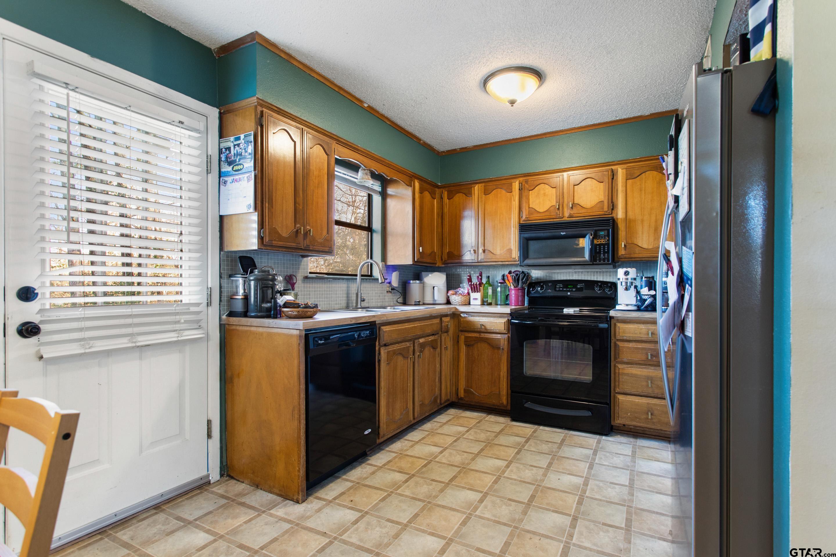 1106 Brad Circle Lindale, TX 75771 - Photo 8 of 27 a kitchen with stainless steel appliances granite countertop a refrigerator and a stove top oven