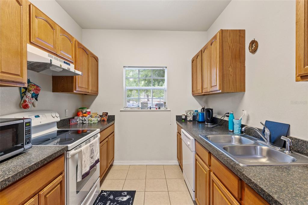 1573 Northwest 29 Road, Unit 3 Gainesville, FL 32605 - Photo 11 of 20 a kitchen with a sink stove top oven and microwave