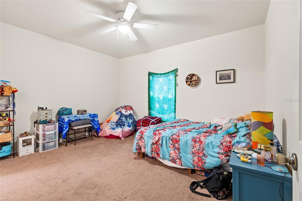 1573 Northwest 29 Road, Unit 3 Gainesville, FL 32605 - Photo 15 of 20 a bedroom with bed and a chandelier