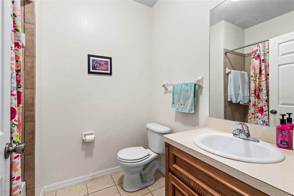 1573 Northwest 29 Road, Unit 3 Gainesville, FL 32605 - Photo 19 of 20 a bathroom with a sink a toilet and a mirror