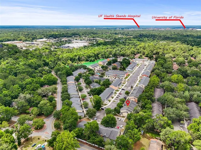 an aerial view of residential houses with outdoor space and trees