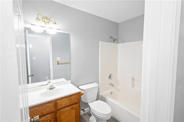 a bathroom with a sink a toilet a large mirror and shower