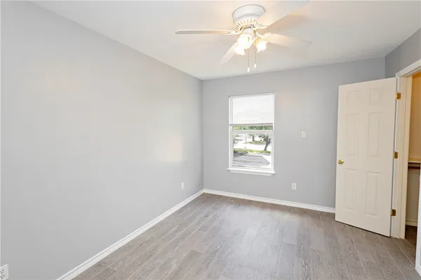 an empty room with a window and a fan