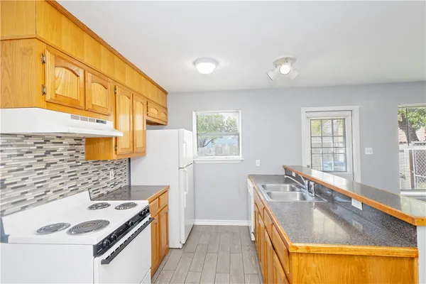a kitchen with stainless steel appliances granite countertop a sink a stove and a refrigerator