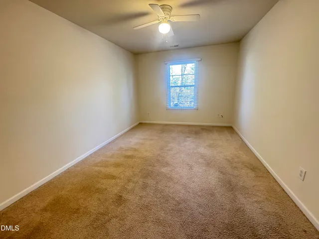 en empty room with windows and chandelier fan