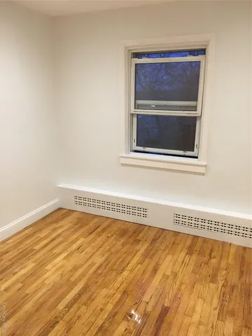 a view of a room with wooden floor and a window