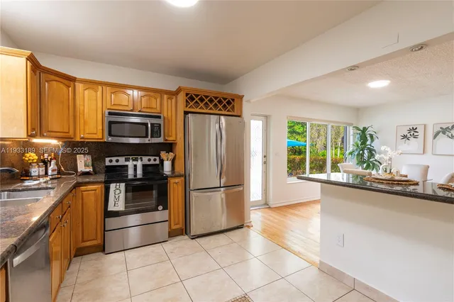 a kitchen with granite countertop a refrigerator and a sink