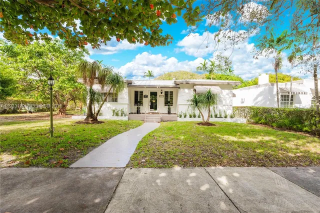 a view of a house with a tree in front of it