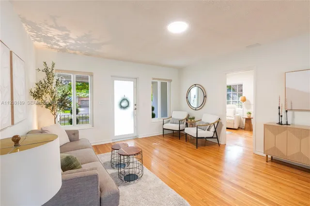 a living room with furniture a table and a large window