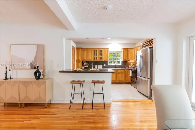 a kitchen with stainless steel appliances granite countertop a refrigerator and a stove top oven