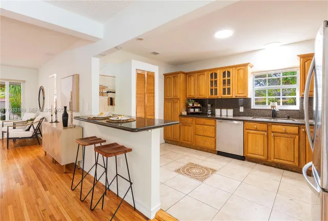 a kitchen with stainless steel appliances kitchen island granite countertop a stove a sink and a granite counter tops with white cabinets