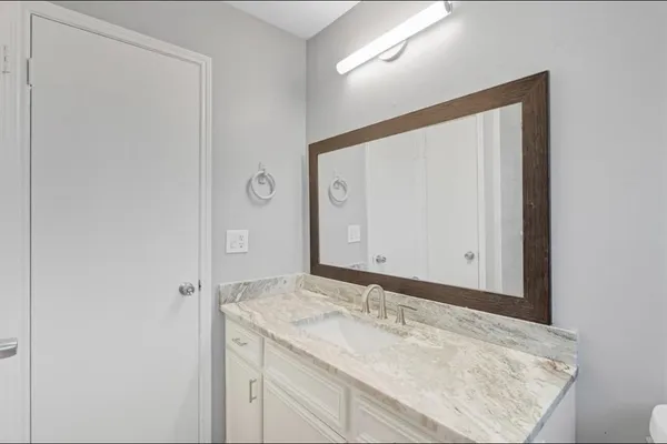 a bathroom with a granite countertop sink and a mirror