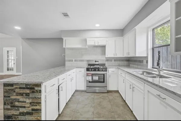 a kitchen with stainless steel appliances granite countertop a stove and a sink