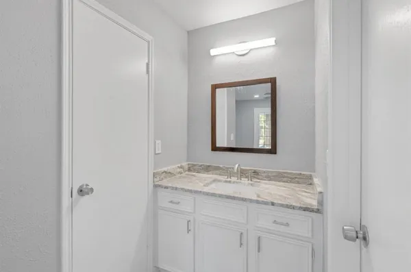 a bathroom with a granite countertop sink and a mirror