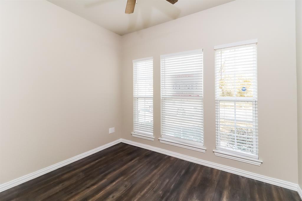 206 Perry Avenue Waxahachie, TX 75165 - Photo 13 of 15 a view of an empty room with wooden floor and a window