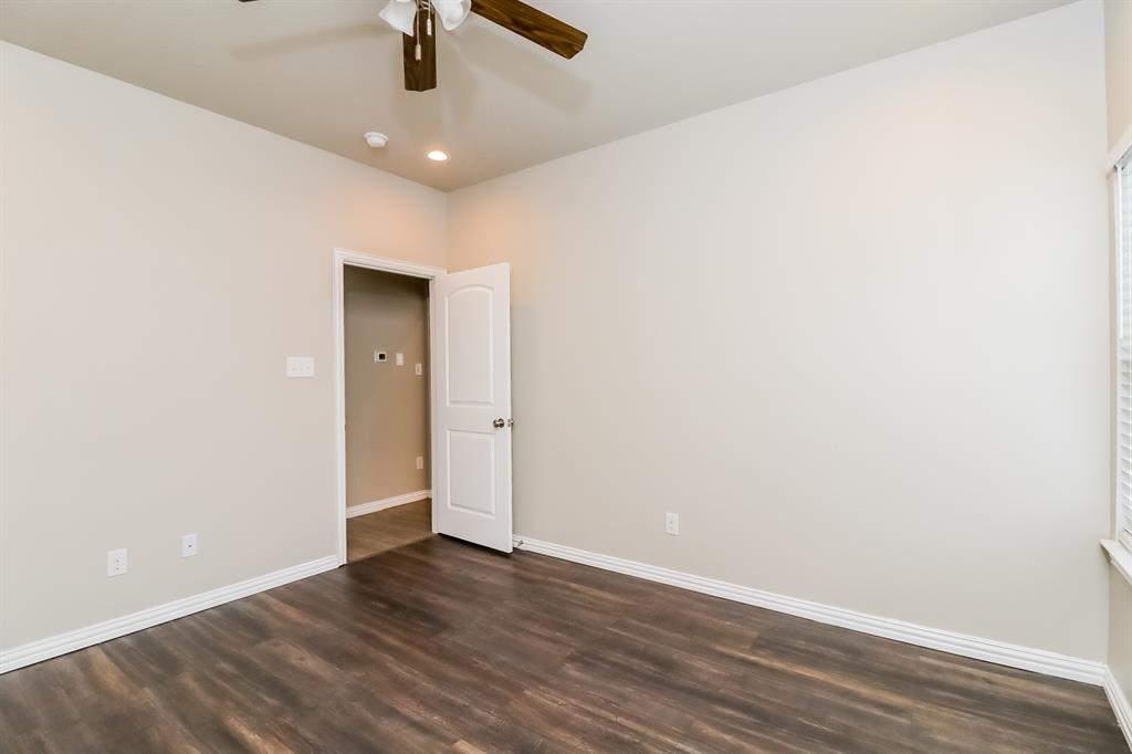 206 Perry Avenue Waxahachie, TX 75165 - Photo 9 of 15 an empty room with wooden floor ceiling fan and window