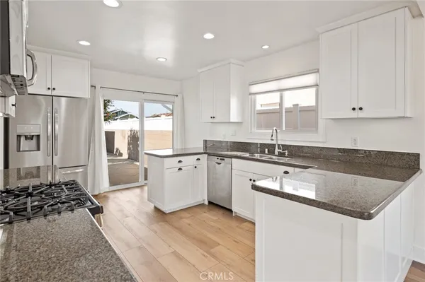 a kitchen with white cabinets and appliances