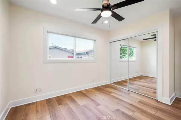 a view of a room with wooden floor and a ceiling fan
