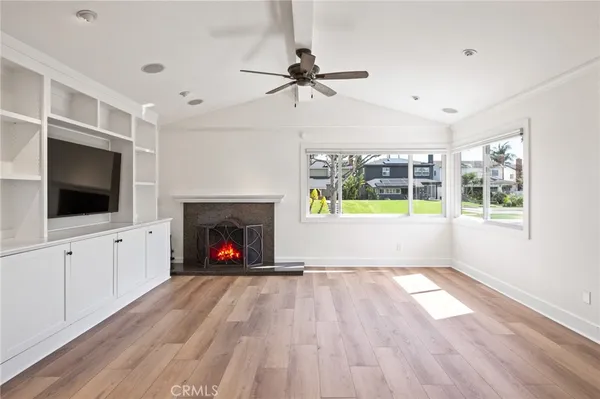 a view of a kitchen with kitchen island a counter top space wooden floor and stainless steel appliances