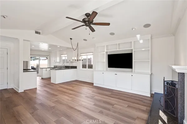 a kitchen with granite countertop white cabinets and refrigerator
